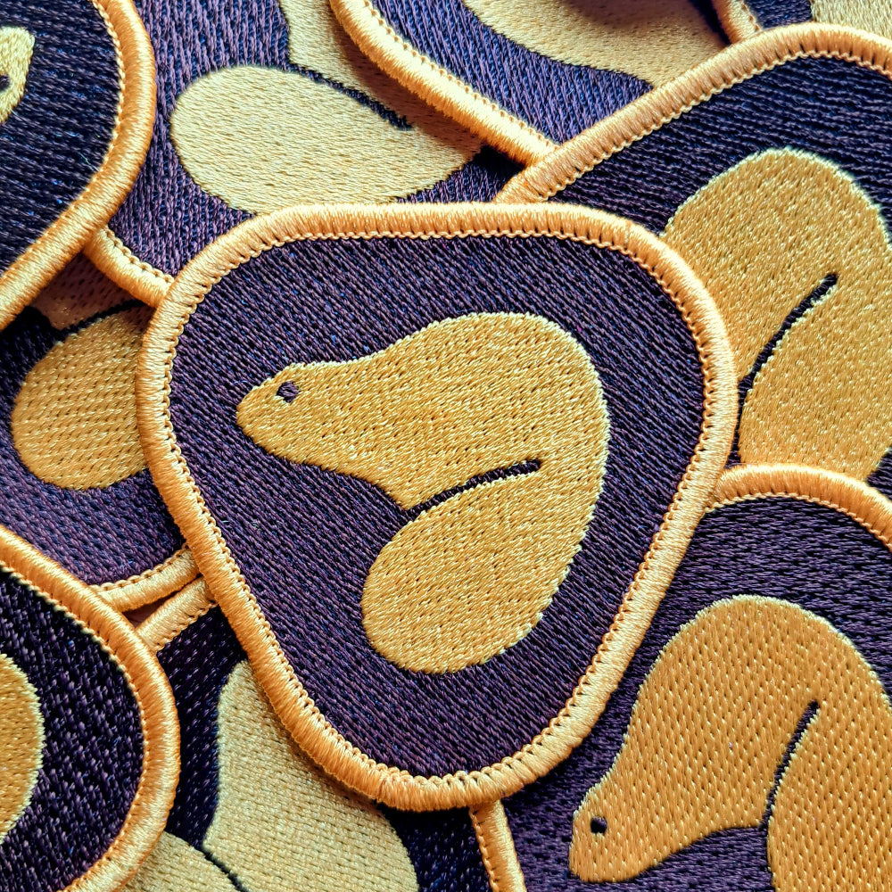 A collection of embroidered patches with a beaver motif, inspired by the old Parks Canada logo, in shades of  brown, and yellow.